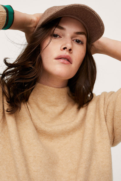 Beige sweater neckline and green-striped cuff detail
