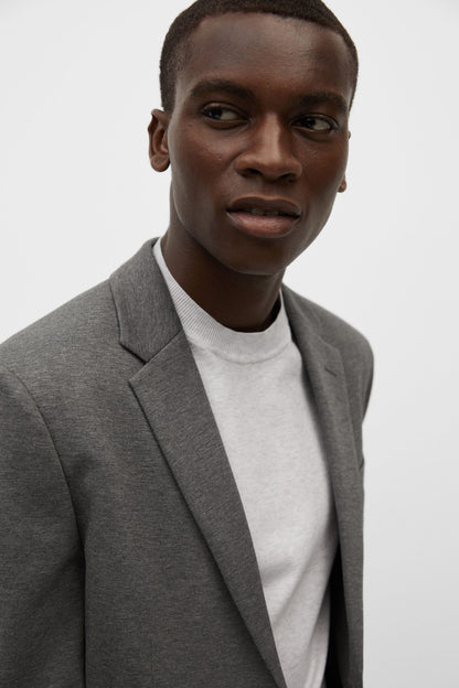 Men's light heather grey blazer with notch lapel, worn over white crew-neck shirt