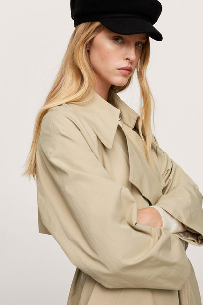 Beige trench coat close-up: notch collar, belted waist, buttoned cuffs