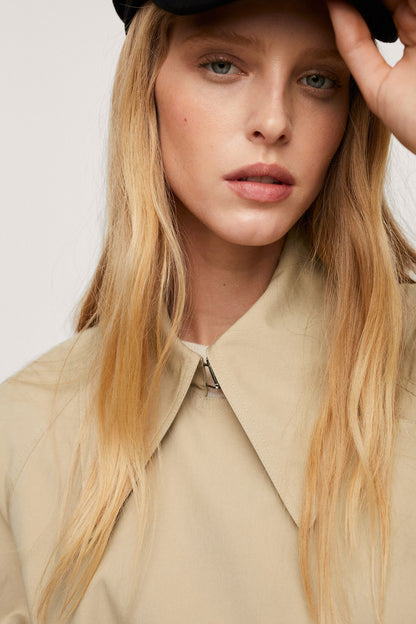 Beige trench coat close-up: turn-down collar and button detail