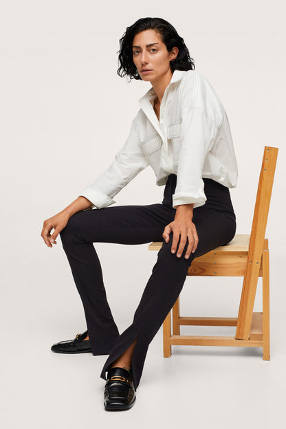 Black slim trousers with ankle slit and straight leg.