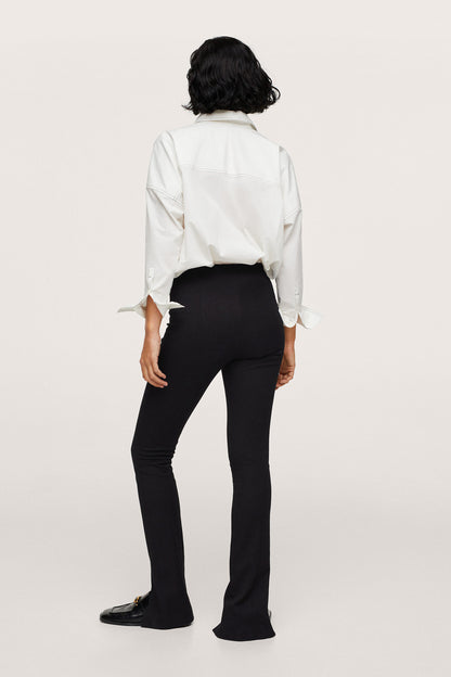 Back view black slim trousers with ankle slit and fitted waistband.