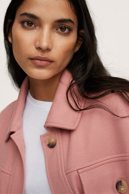 Pink button-up jacket with pointed collar, flap pockets, and gold-tone buttons