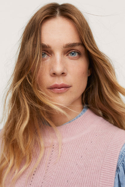 Pastel pink ribbed knit sweater with crew neckline, close-up