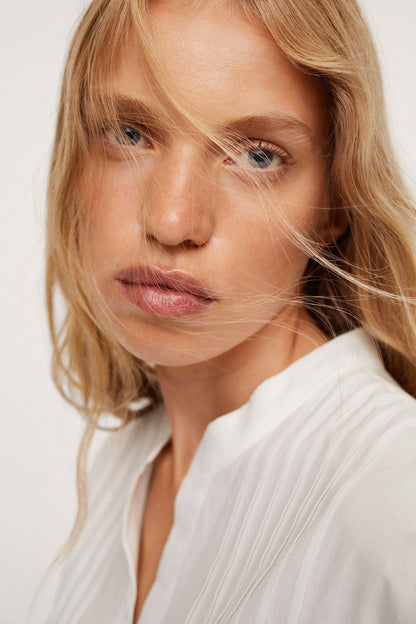 White button-up blouse with pointed collar and vertical placket
