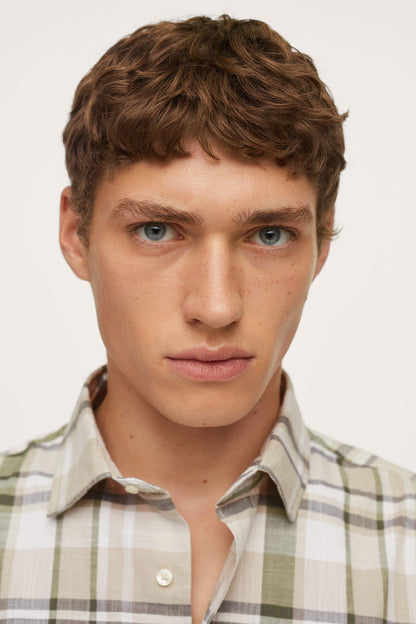 Men’s plaid button-up shirt close-up, collar and top buttons visible.