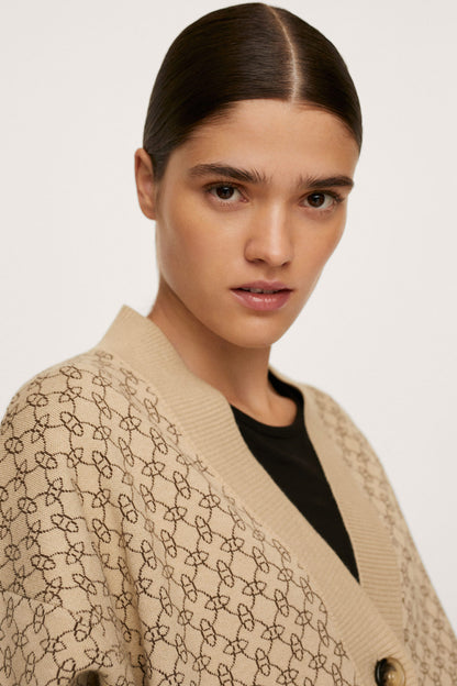 Beige patterned blazer close-up at shoulder with gold-tone buttons