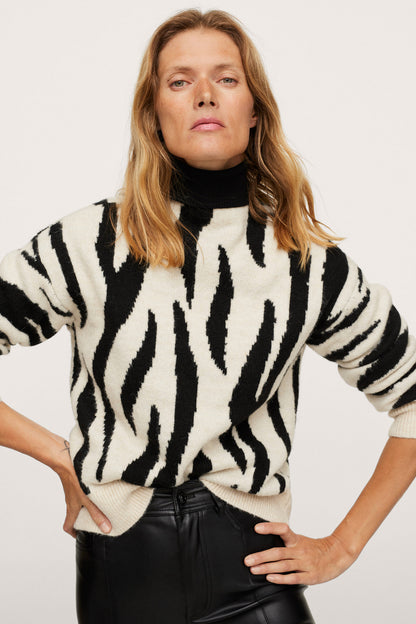 Zebra-striped knit sweater with long sleeves and crew neck, worn over black top