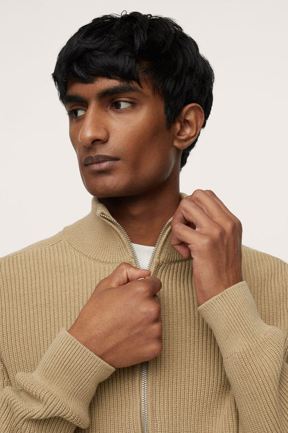 Beige ribbed knit zip-up sweater close-up, zipper and stand collar
