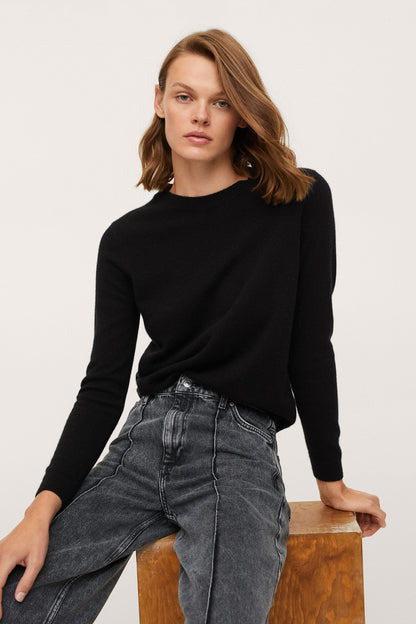 Black crewneck long-sleeve sweater with grey wide-leg jeans