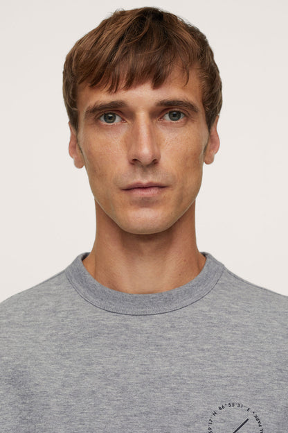 Heather grey crewneck sweatshirt close-up with small circular chest logo