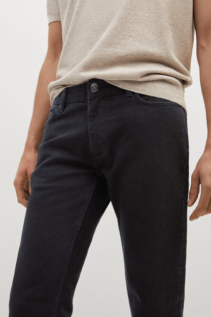 Close-up of black denim jeans with button fly and front pockets