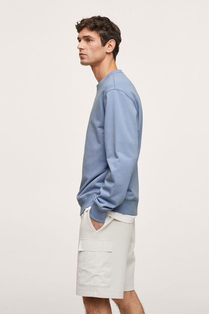 Sky blue crewneck sweatshirt, side profile with ribbed cuffs