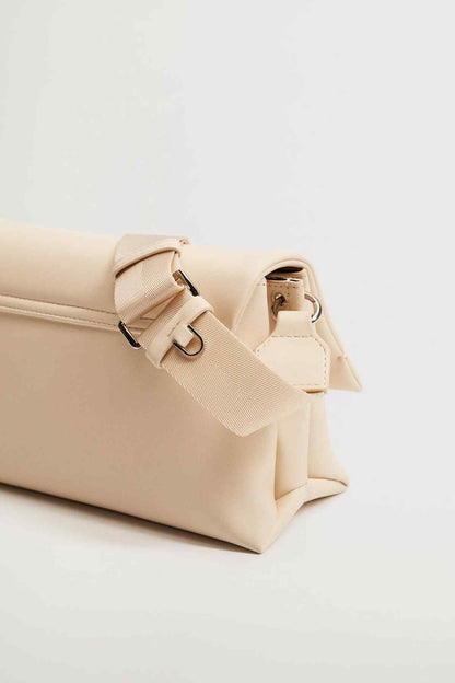 Off-white shoulder bag with buckle strap detail and front flap, angled view