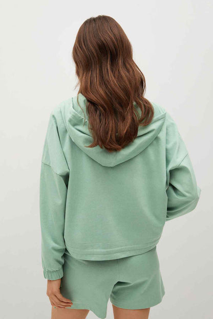 Pastel green zip-up hoodie and drawstring shorts set, back view with hood