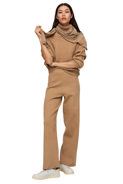 Tan knit turtleneck sweater with cable pattern and wide-leg trousers