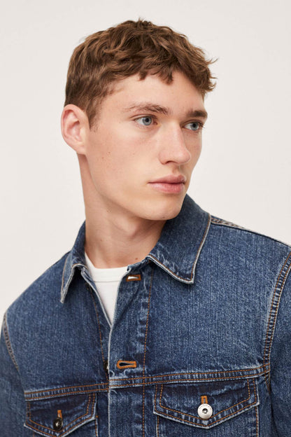 Close-up of dark blue denim jacket collar and buttoned chest pocket
