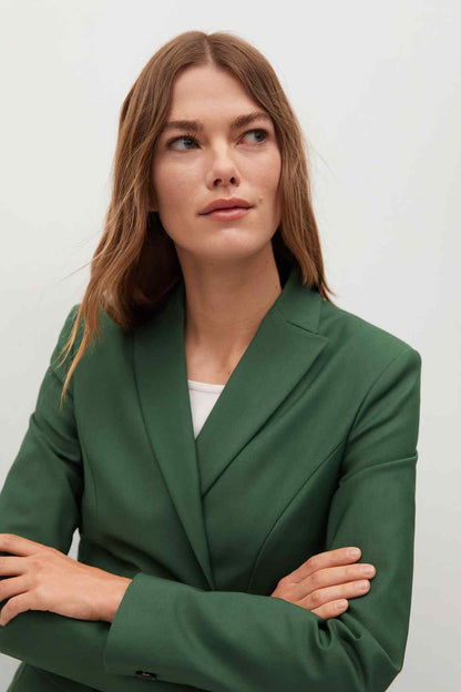 Close-up of dark green women's blazer with notched lapels and front button detail