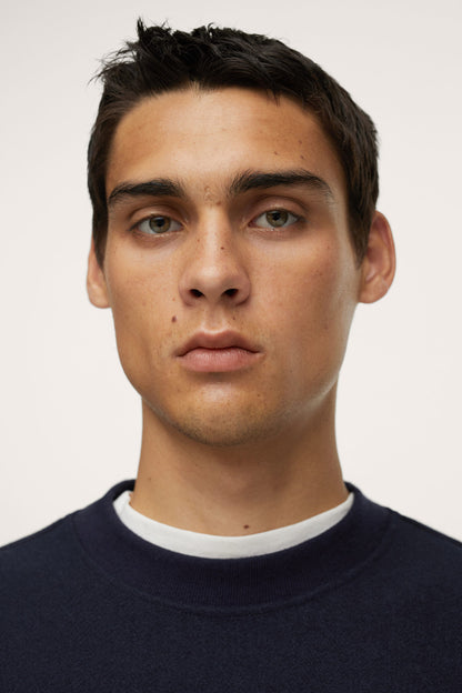Dark navy crewneck sweatshirt neckline detail with white jersey trim