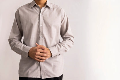 Grey button-up shirt close-up on model, long sleeves and buttoned front