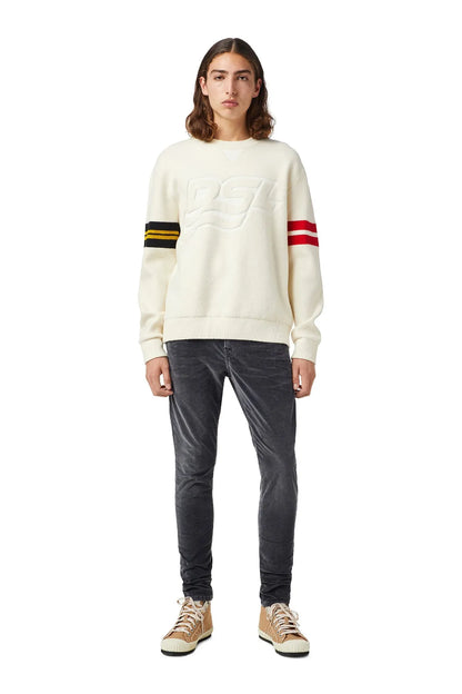Cream crewneck sweatshirt with large raised D logo and striped sleeves, worn with jeans