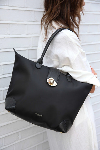 Black tote bag with gold clasp, side base, and smooth top handles