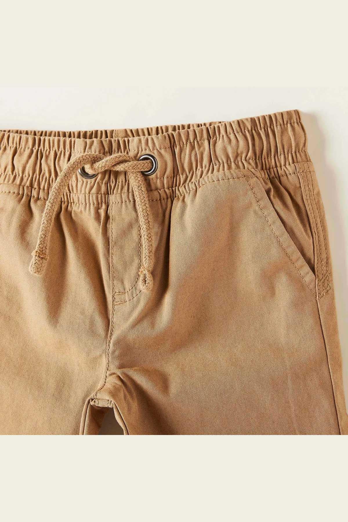 Brown baby shorts with elastic waist, loop drawstring, and curved fly