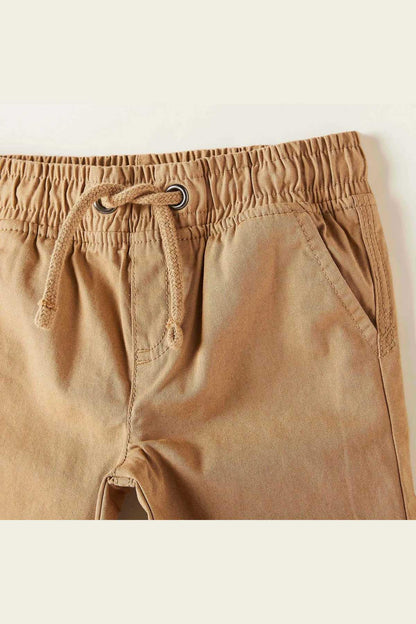 Brown baby shorts with elastic waist, loop drawstring, and curved fly