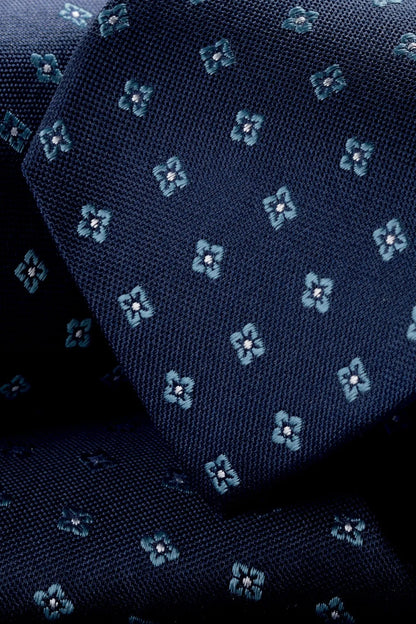 Charles Tyrwhitt blue tie close-up with teal clover motifs