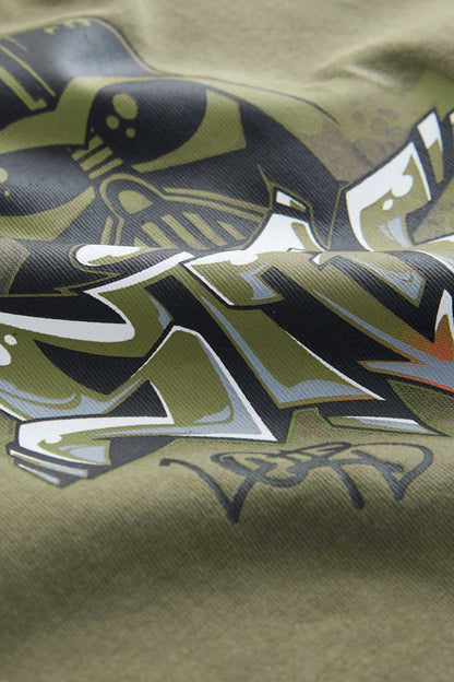 Olive green graphic T-shirt fabric close-up with bold character artwork