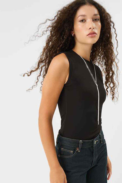 Accessorize silver long necklace with vertical drop pendant, worn with dark top