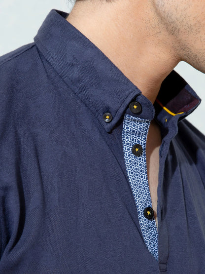Navy polo shirt collar with gold buttons and patterned inner placket trim