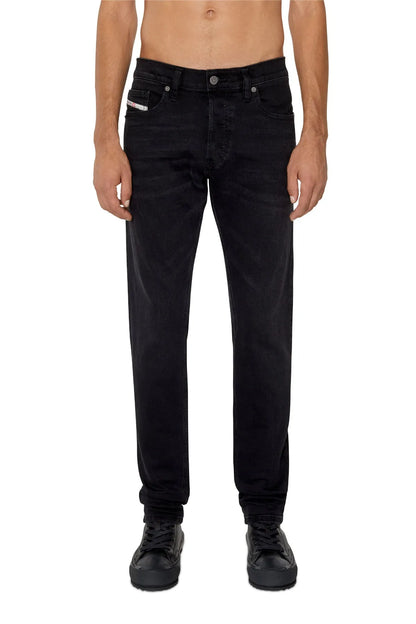 Black denim jeans on model, straight-leg fit with button fly
