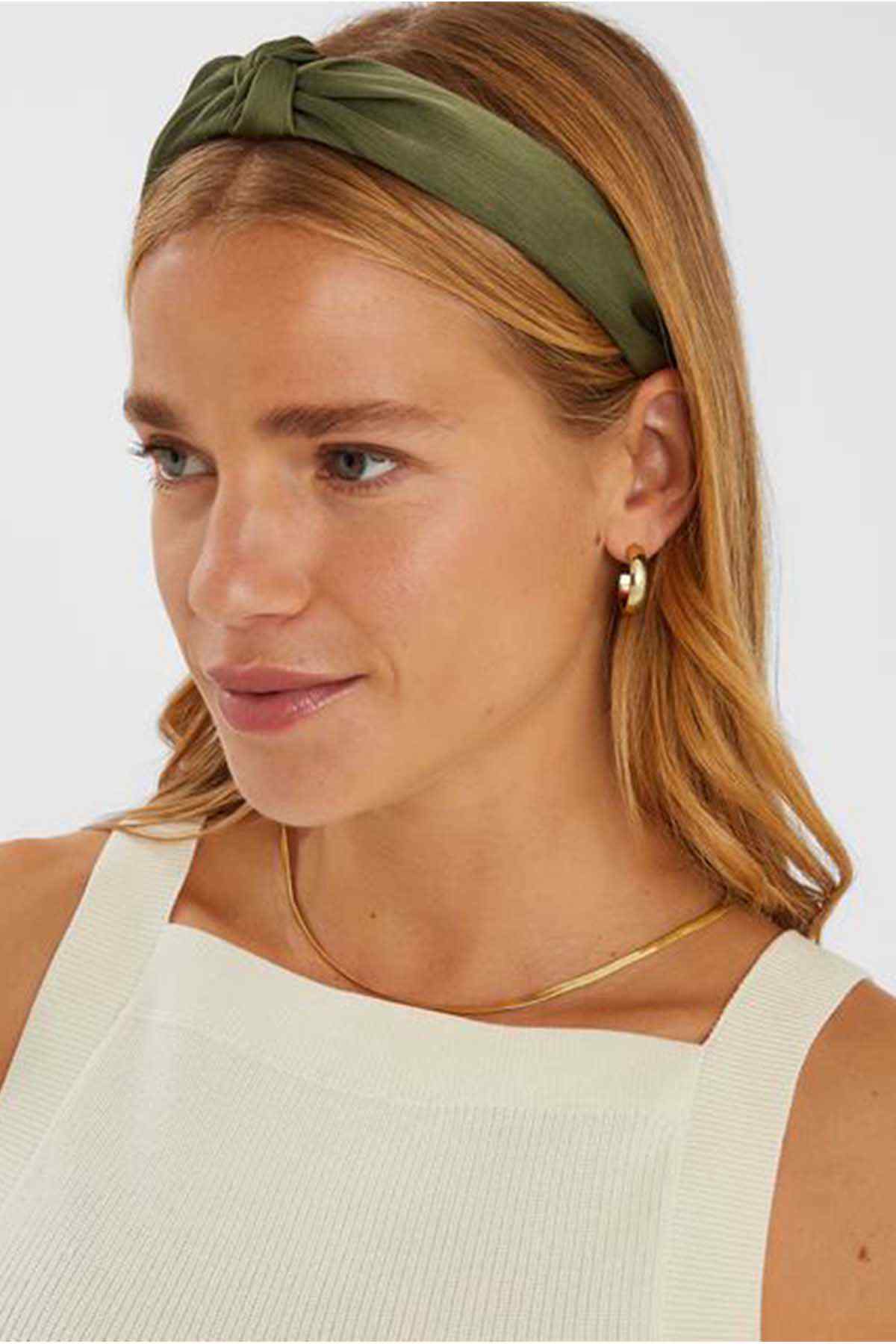 Khaki fabric knotted headband with twisted front, worn on head