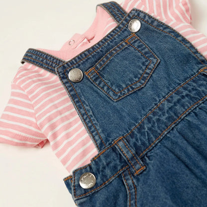 Babyshop denim pinafore close-up with chest pocket, round metal buttons, stitched seams