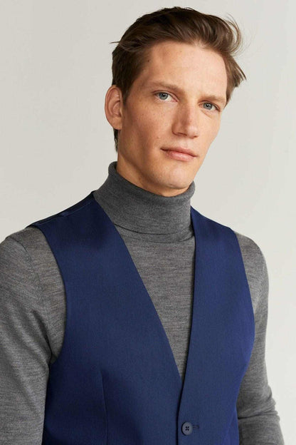 Blue suit vest with V-neck and button front over gray turtleneck