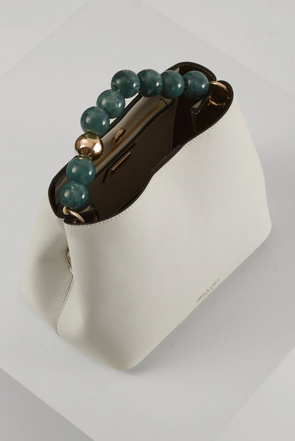 White bucket bag with green beaded handle, brown interior, and gold hardware clasp