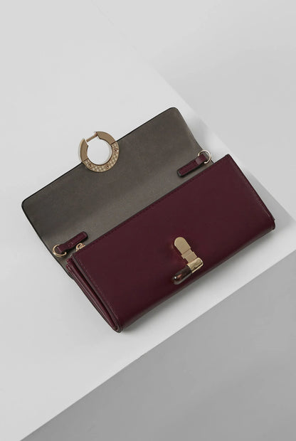 Berry foldover wallet with flap and bar clasp details, gold-tone hardware