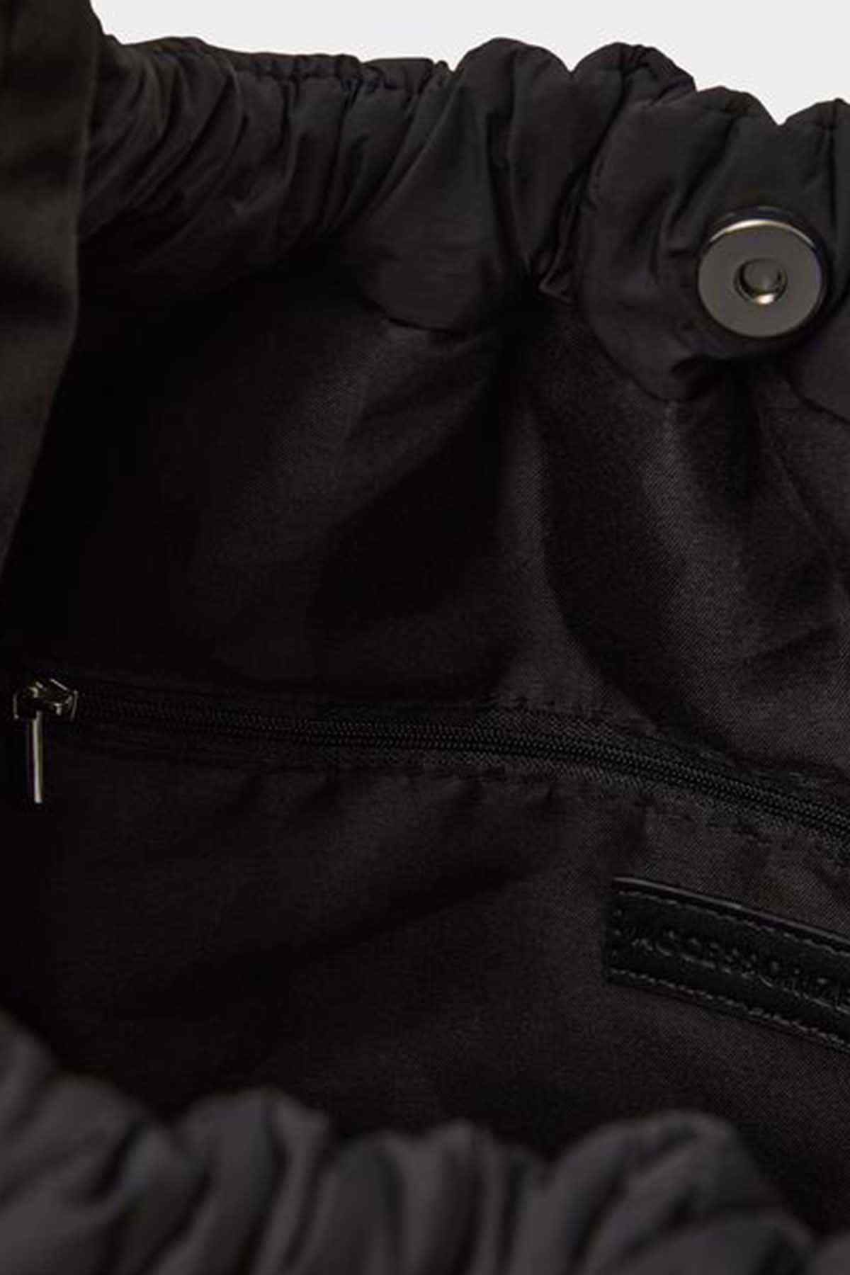 Black fabric bag close-up with zipper and logo patch