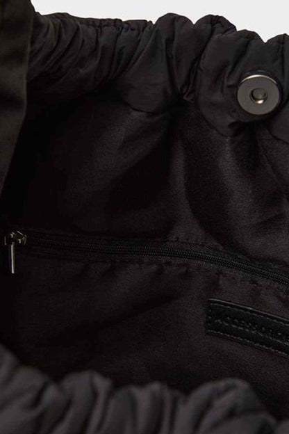 Black fabric bag close-up with zipper and logo patch