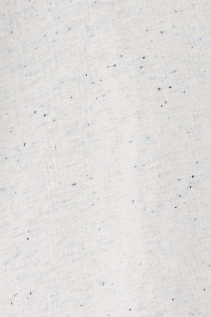 Speckled white knit fabric with tiny blue flecks, close-up