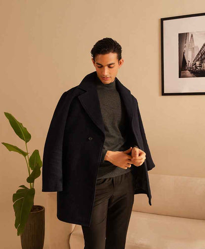 Dark fitted overcoat with open front, notched lapels, and long sleeves.