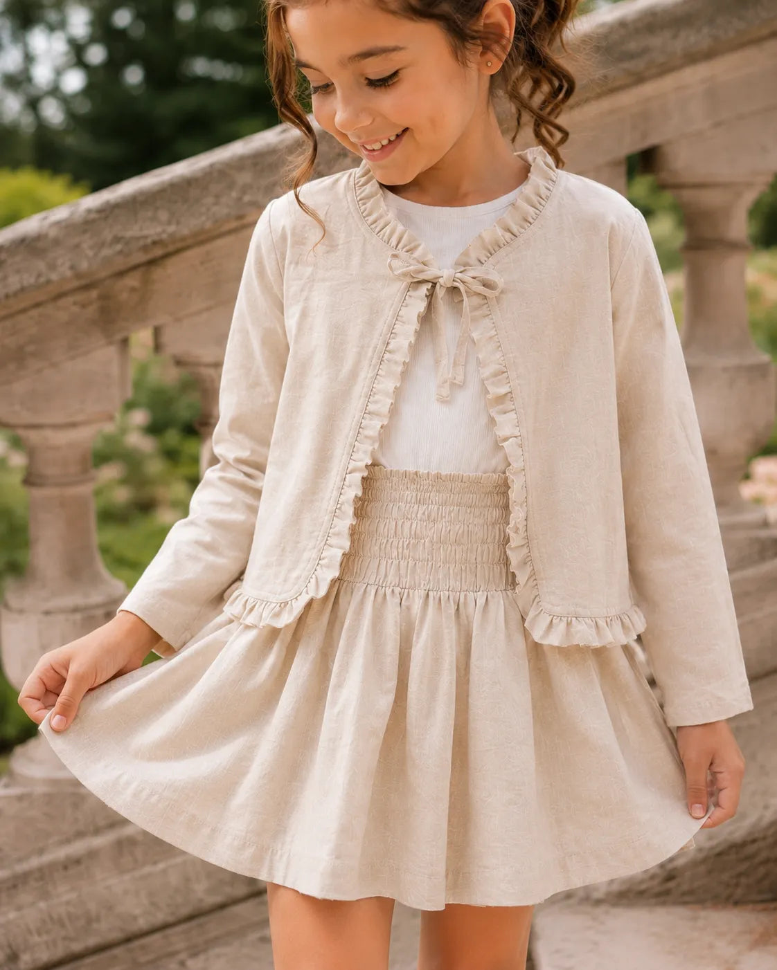 Beige girls dress with ruffle-trimmed front and smocked tiered skirt