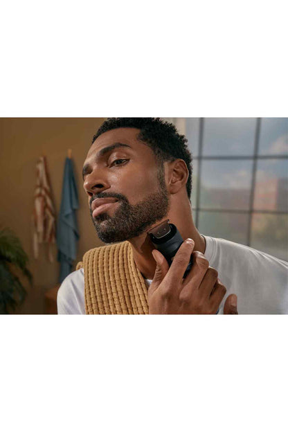 Black electric beard trimmer at chin and cheek area