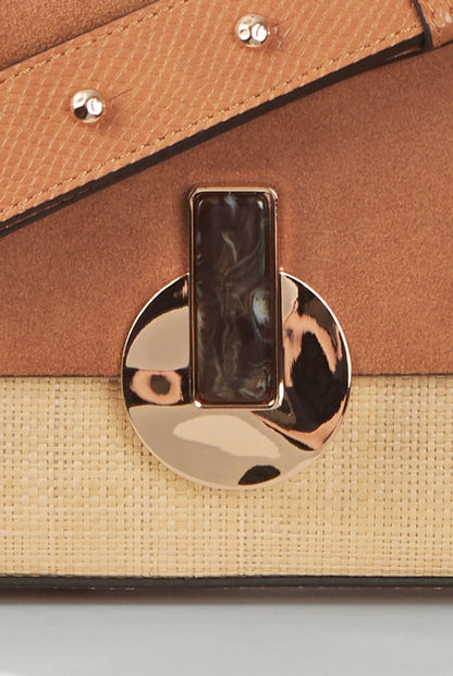 Close-up of brown flap with gold-tone clasp and stud details
