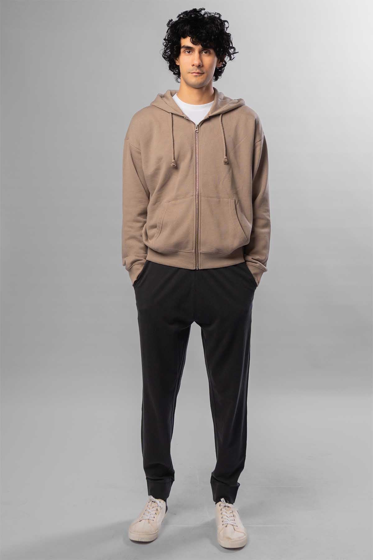Men's taupe zip-front hoodie with hood, worn with black jogger pants