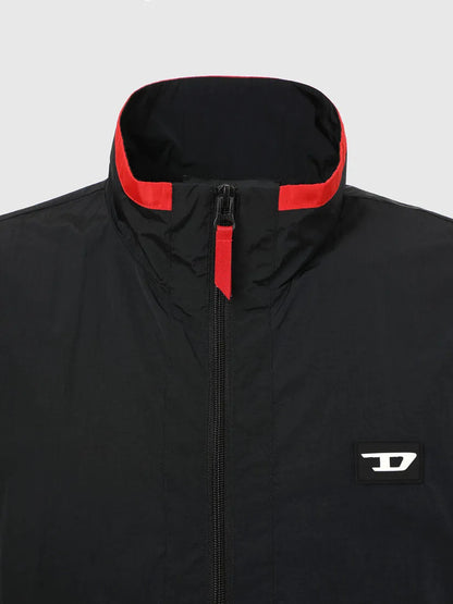 Black windbreaker jacket with red-trim hood, central zipper, and chest logo patch