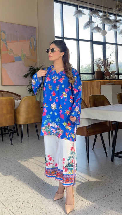 Blue floral printed long kurta with white pants, side view with patterned border hem