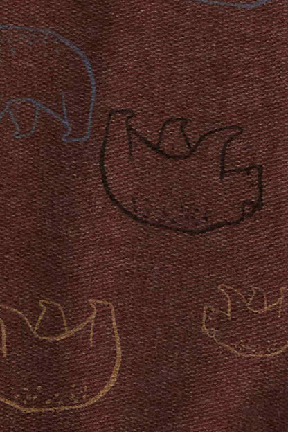 Close-up of brown fabric with embroidered dinosaur outline print