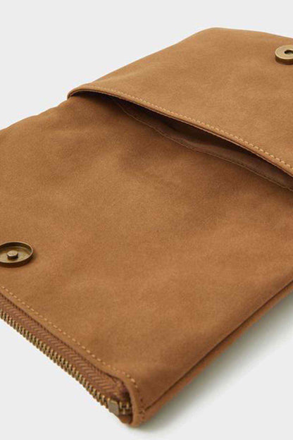 Tan suede clutch bag close-up with flap edge and metal snap button